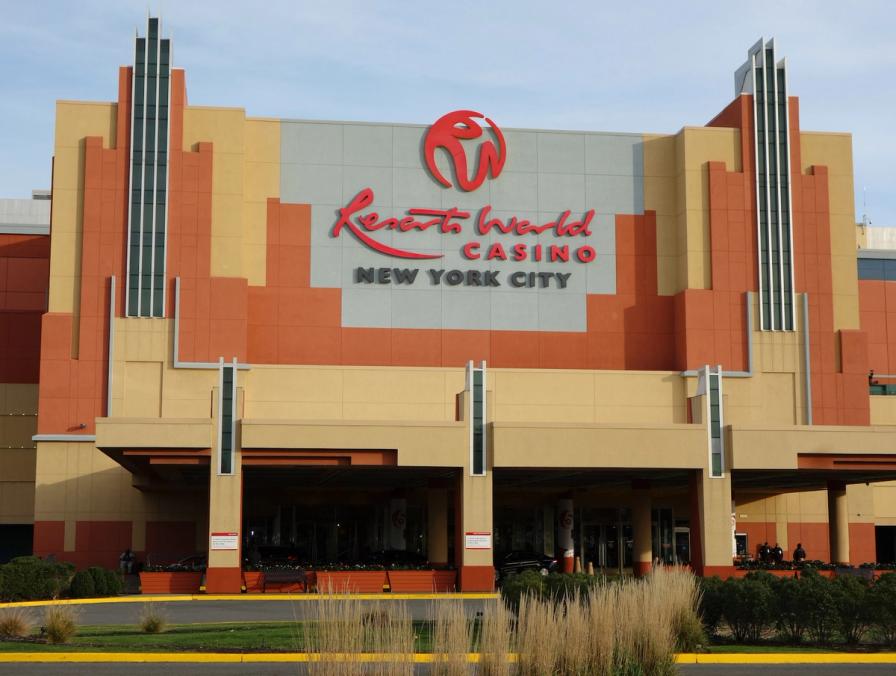 The exterior facade of Resorts World Casino in New York City, featuring its large red sign and modern architecture.