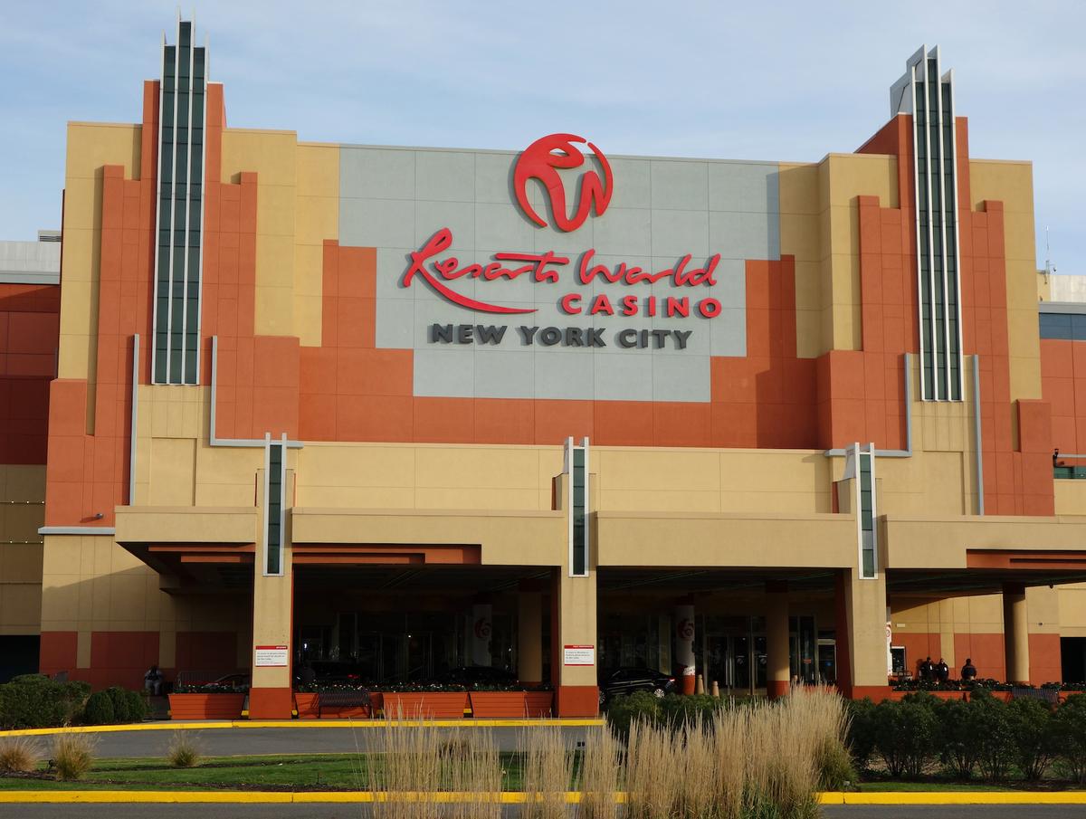 The exterior facade of Resorts World Casino in New York City, featuring its large red sign and modern architecture.