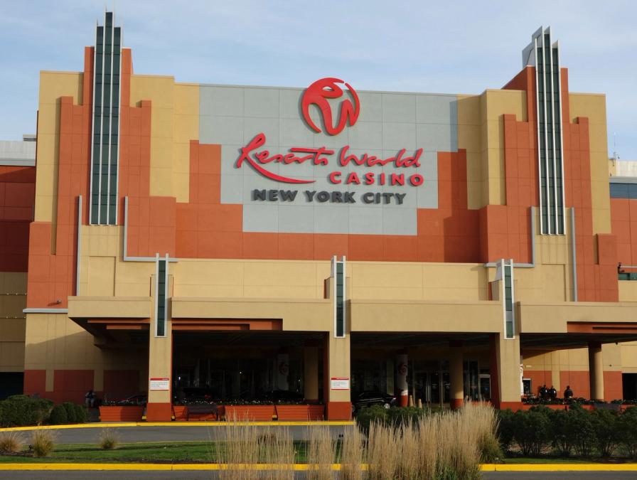 The exterior facade of Resorts World Casino in New York City, featuring its large red sign and modern architecture.