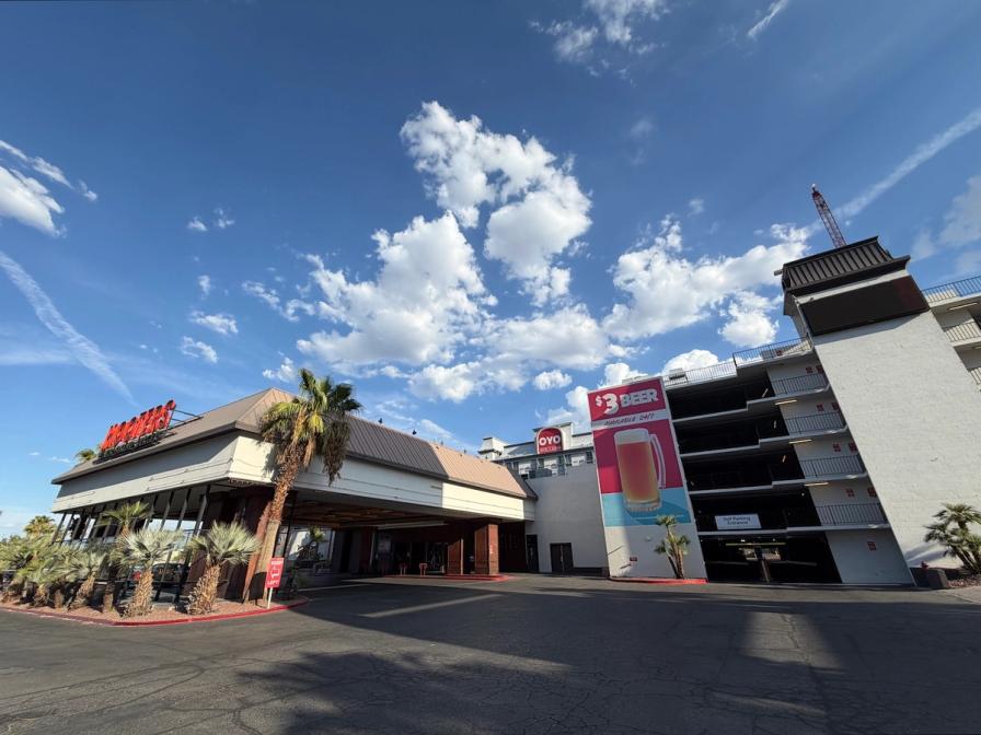 OYO Hotel and Hooters restaurant exterior in Las Vegas, with a parking garage featuring a large "$3 Beer" banner under