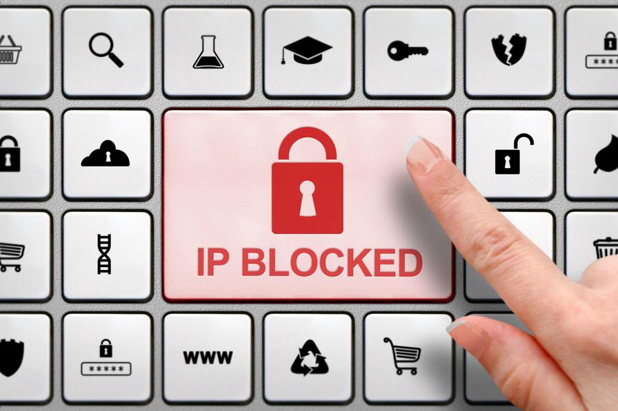 IP Blocked concept, finger above the button on the keyboard