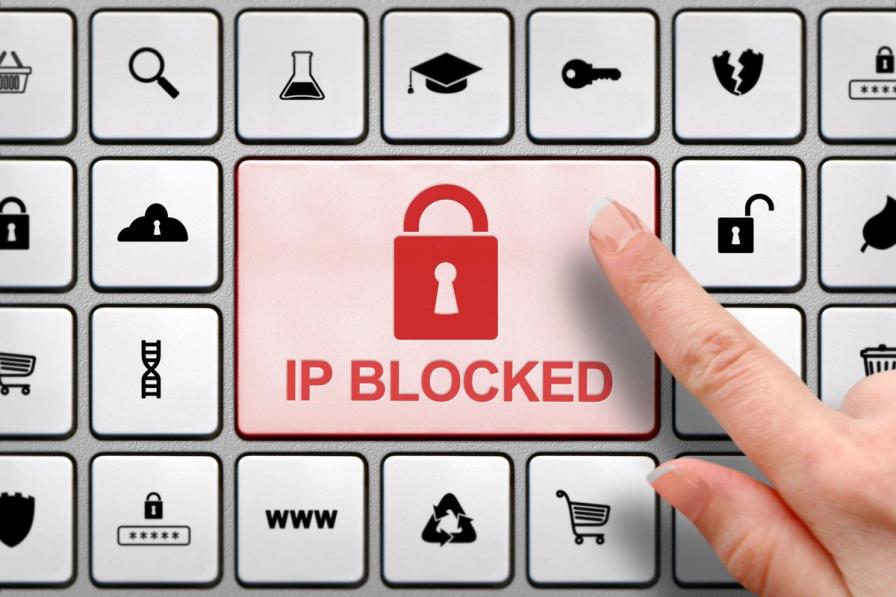 IP Blocked concept, finger above the button on the keyboard