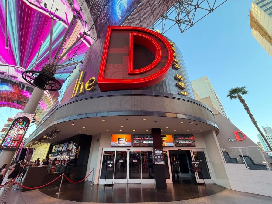 The entrance of the D Las Vegas casino, featuring a massive red neon "D" sign beneath the colorful Fremont Street canopy.