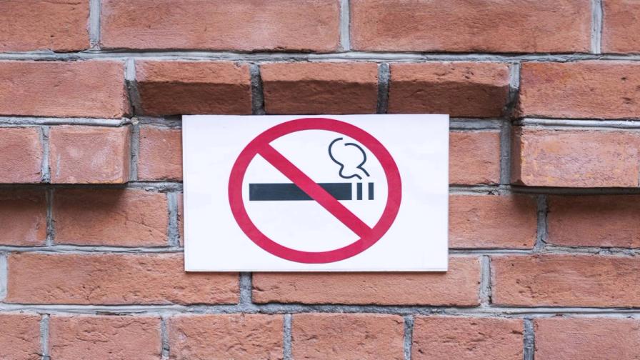A smoking ban sign on a brick wall