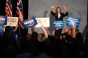 Amy Acton waves to a crowd holding campaign signs at an Ohio political rally.