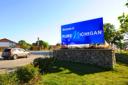 A large blue roadside sign reading "Welcome to Pure Michigan" on a stone base.