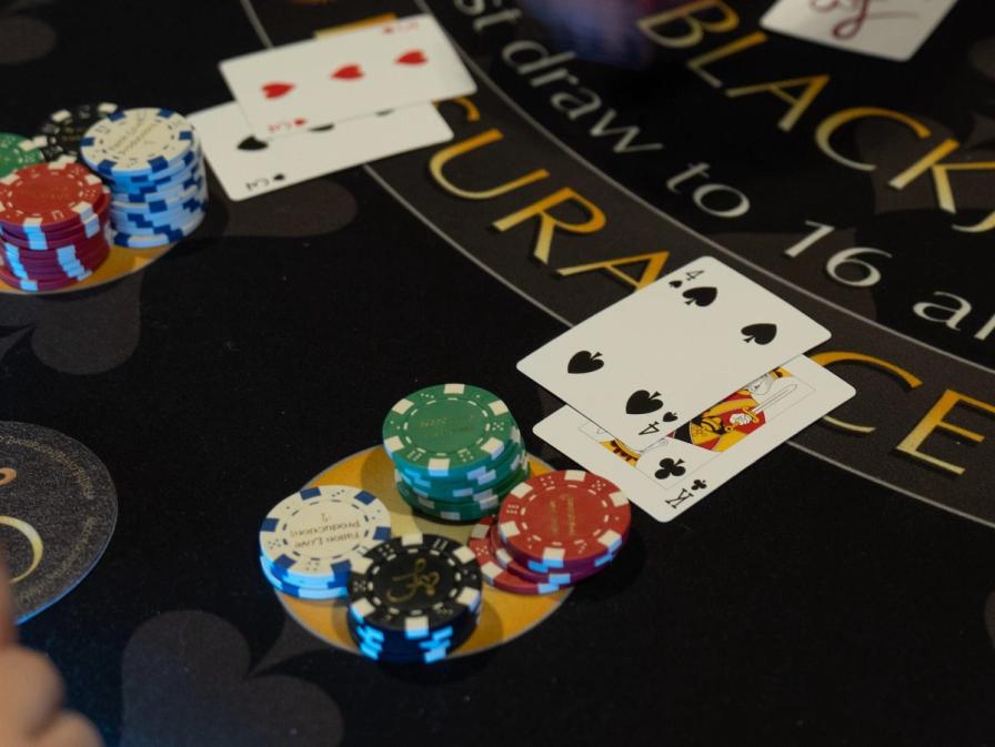Playing cards and stacks of poker chips on a blackjack table.