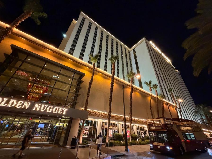 The Golden Nugget hotel and casino in Las Vegas at night, with palm trees and a double-de