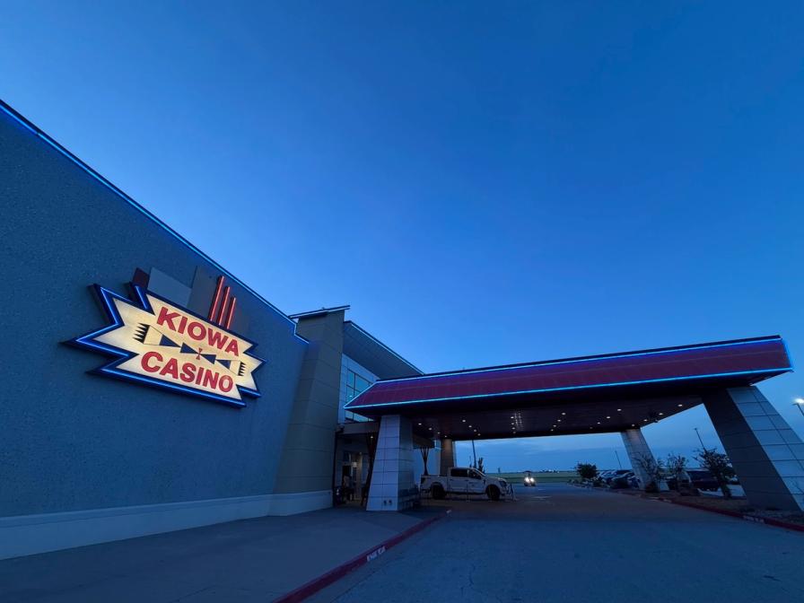Exterior of Kiowa Casino at dusk, showing the illuminated sign and covered entrance under a twilight sky.