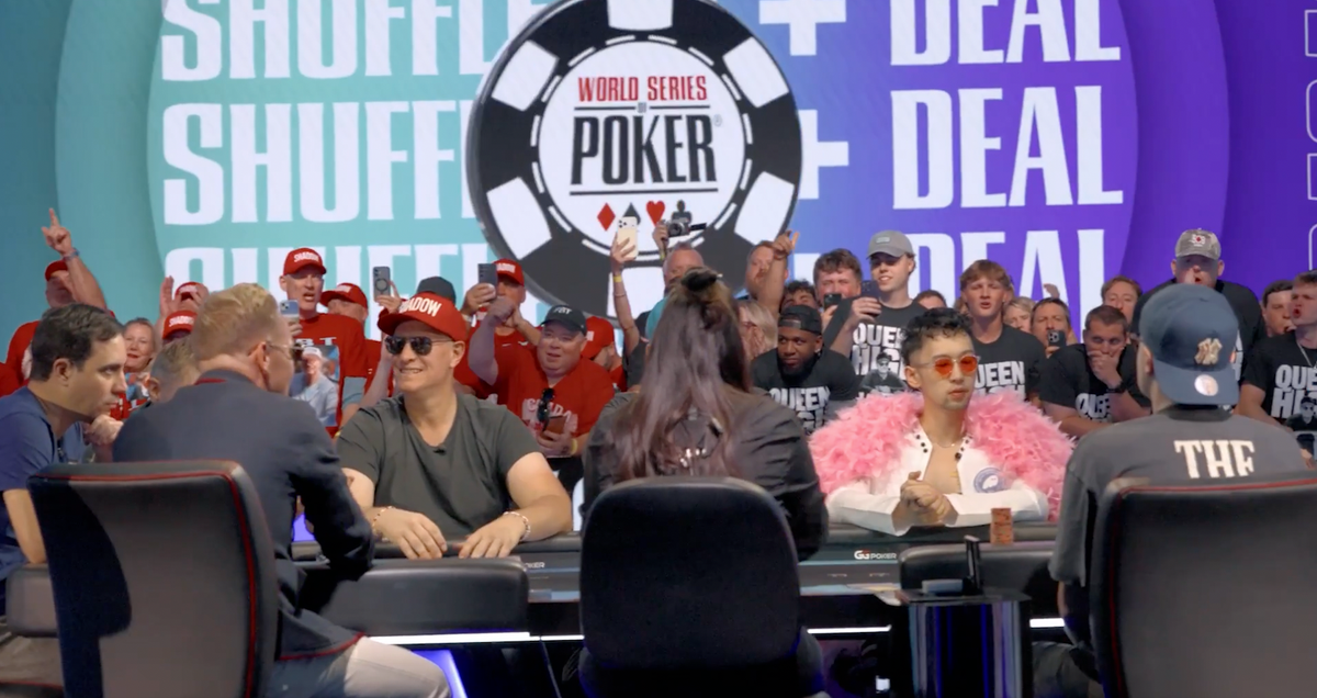 Players seated at the World Series of Poker final table with a large WSOP logo and spectators in the background.