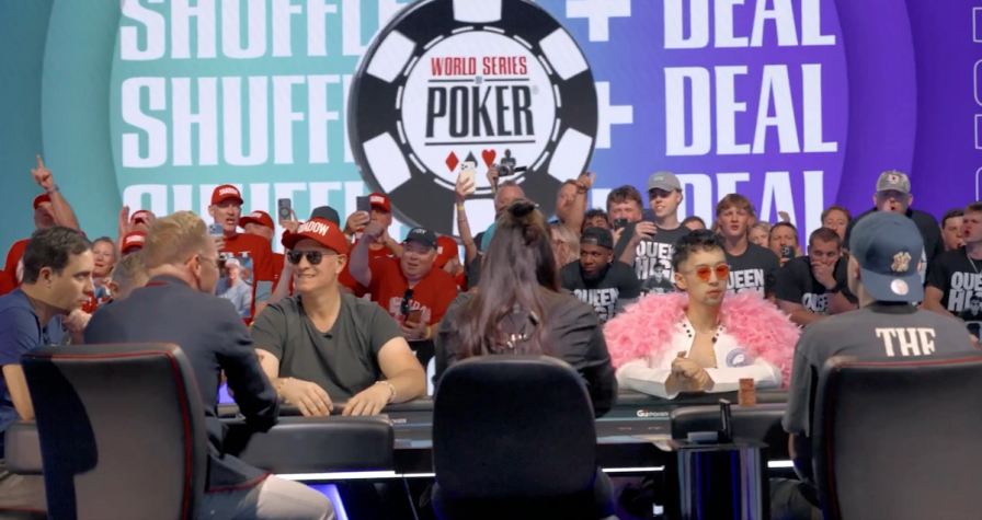 Players seated at the World Series of Poker final table with a large WSOP logo and spectators in the background.