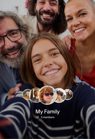 A young girl smiles in a family selfie, with three adults smiling behind her and "My Family" text with five profile pictures below.