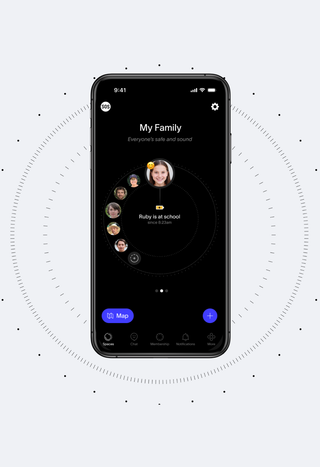 A black smartphone displays a "My Family" app in dark mode, showing a central profile for "Ruby is at school" surrounded by other family members' profiles, with a map button at the bottom.