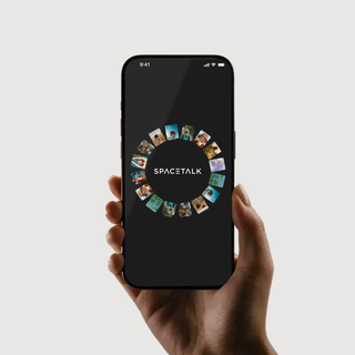 a person is holding a phone that says spacetalk on the screen