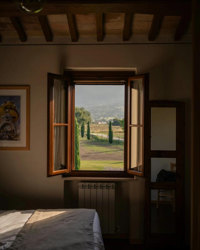 Camera matrimoniale con travi a vista e toni caldi
