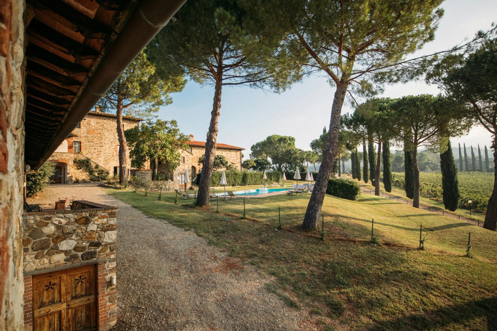 Piscina a sfioro tra i pini marittimi, con il borgo sullo sfondo