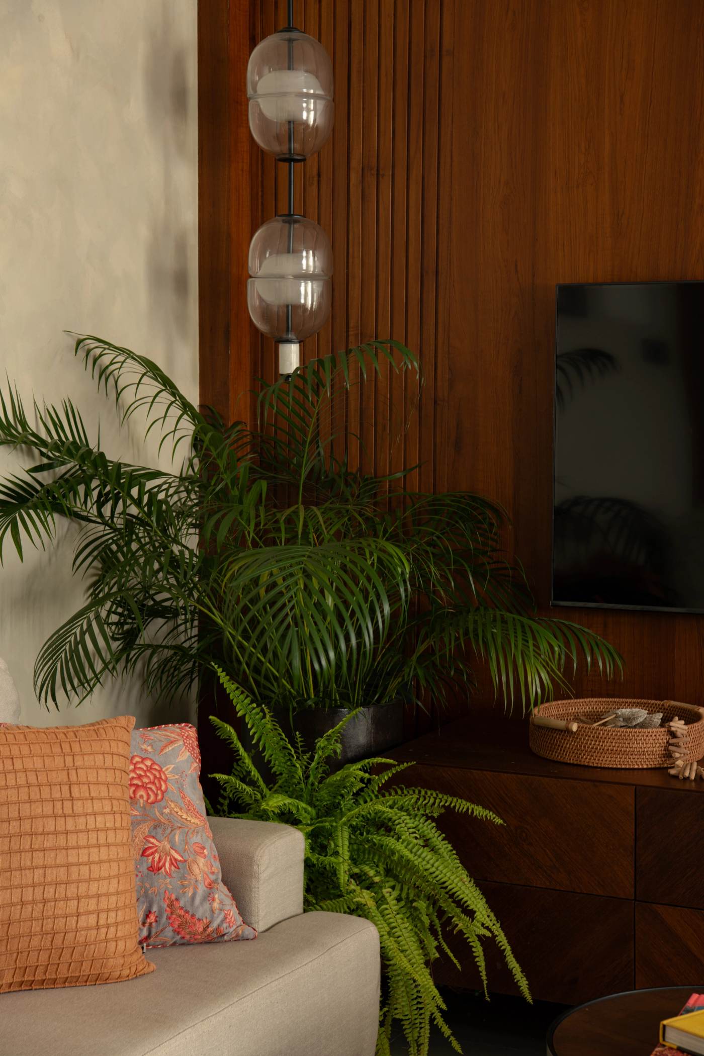 Palms and ferns banked against the fluted timber panelling