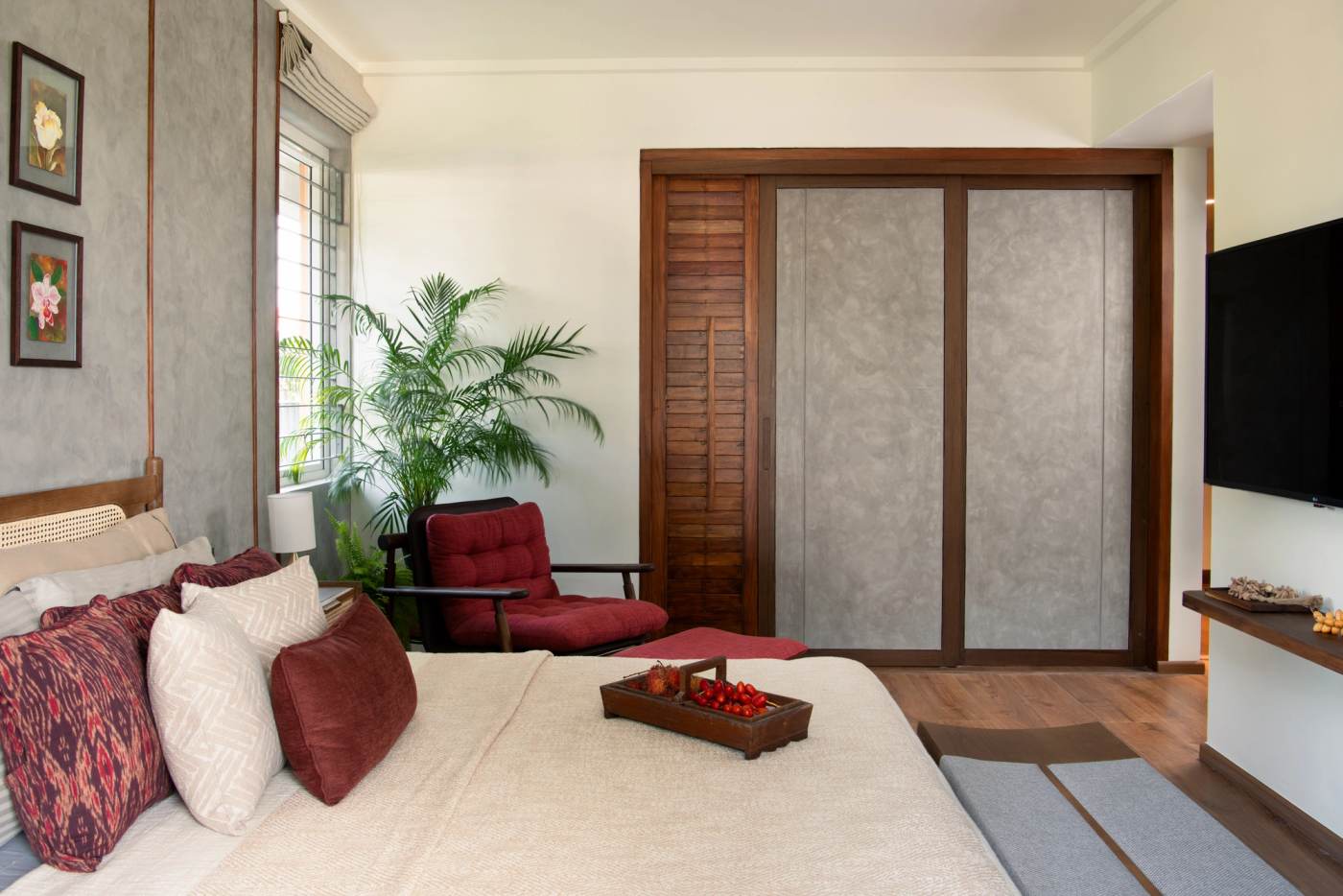 The main bedroom, sliding wardrobes facing a red armchair at the window