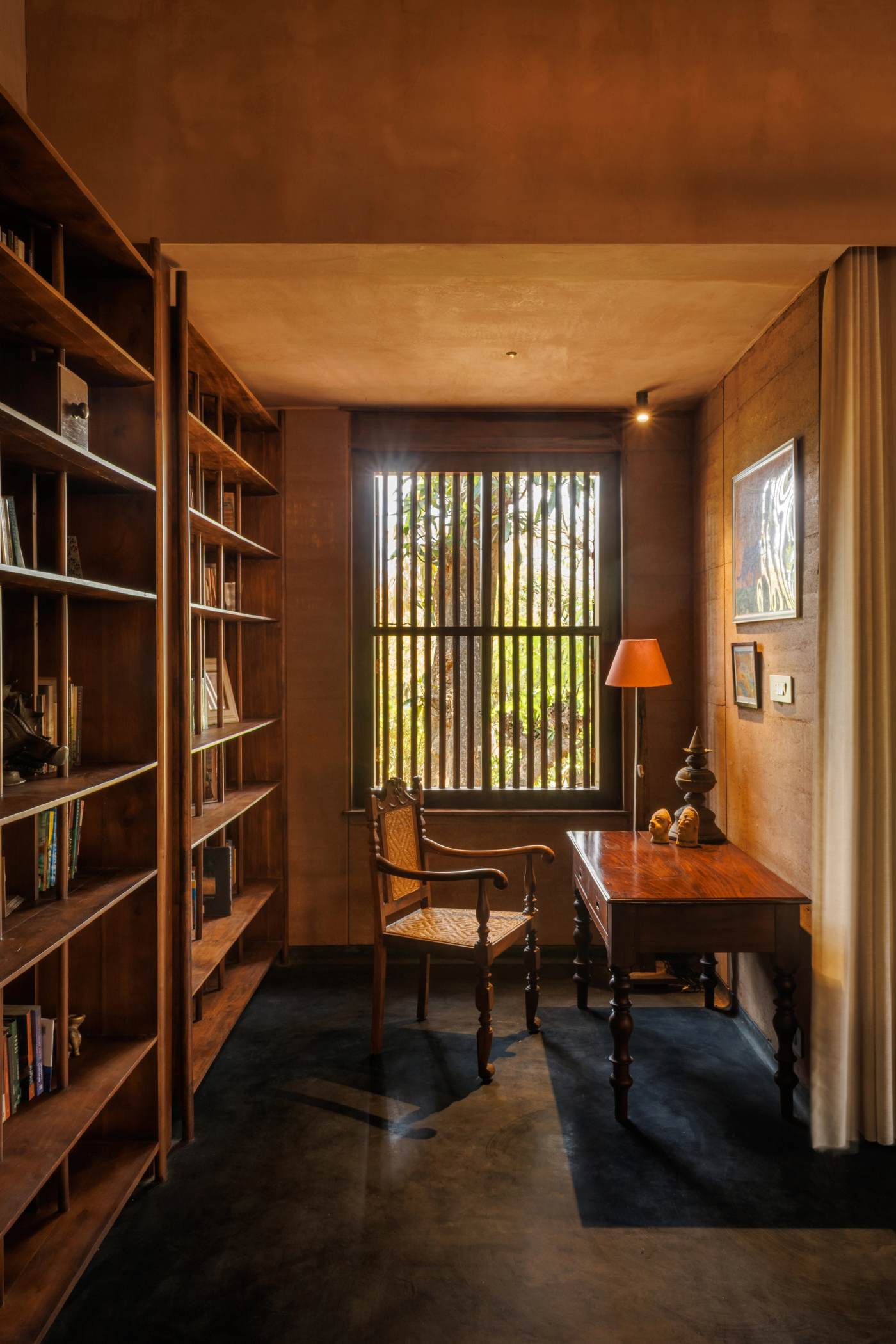 The library, framed by a salvaged window looking over the fields