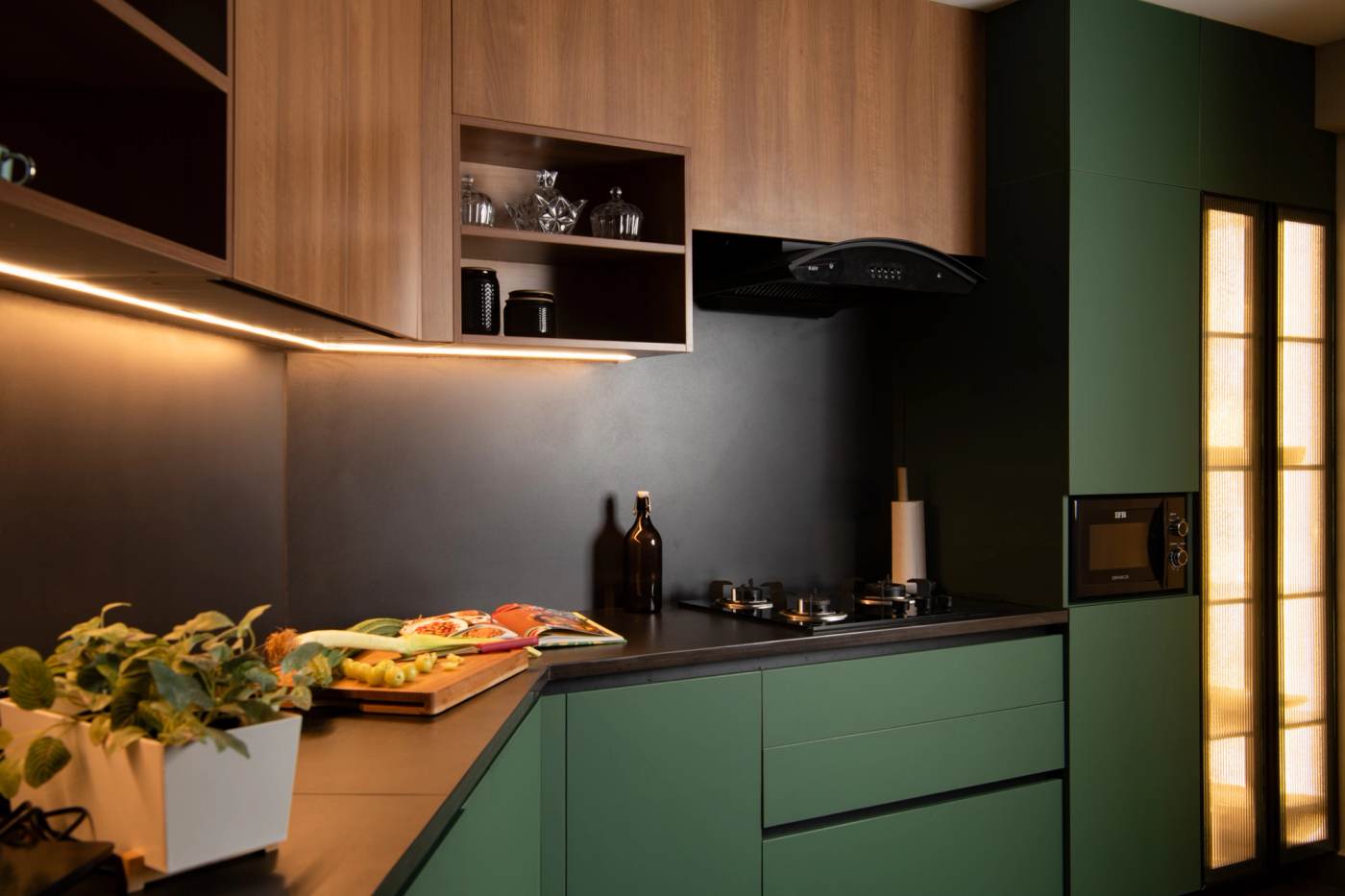 The kitchen in green, timber uppers above a black counter