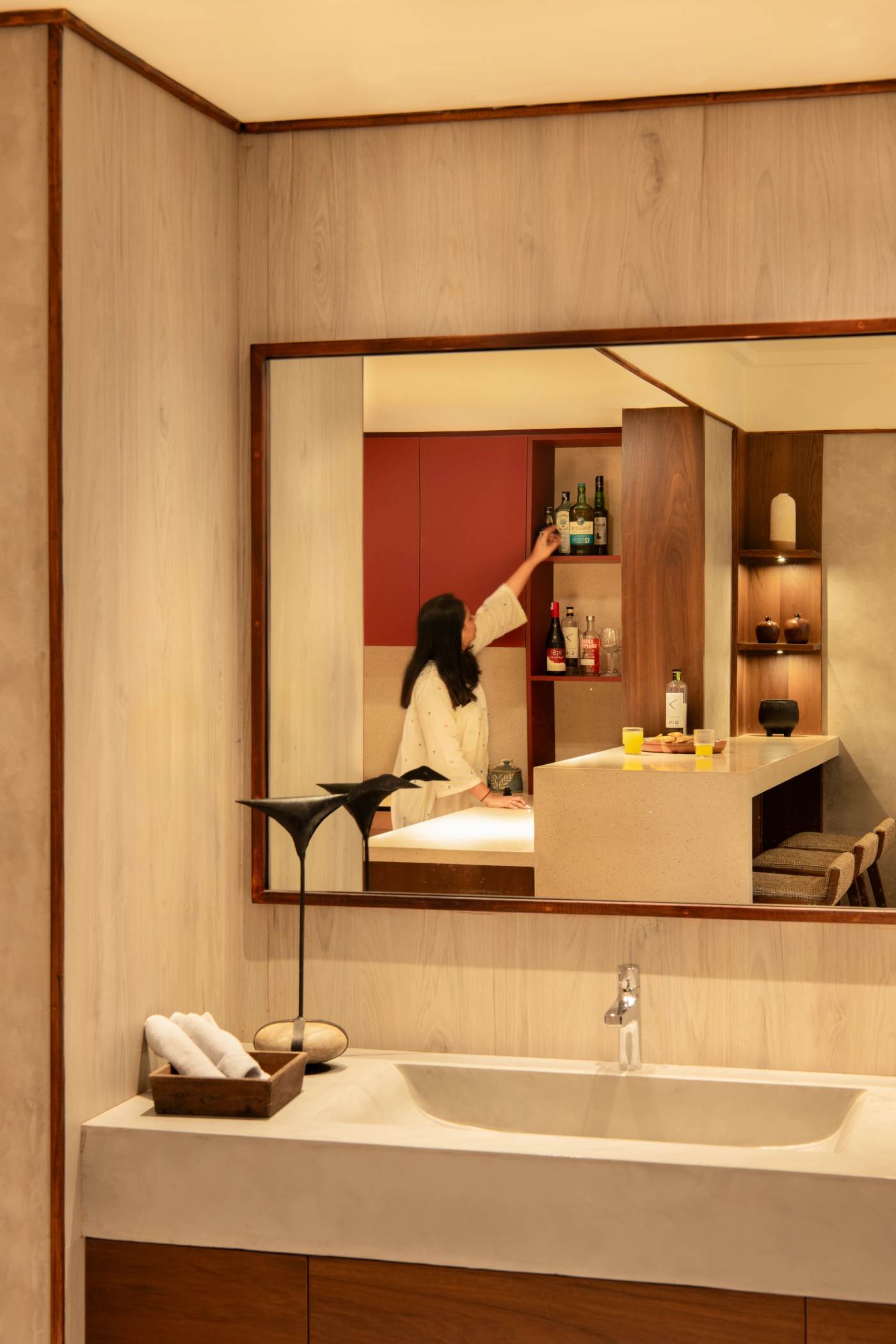 The washbasin mirror, catching the bar and the room beyond