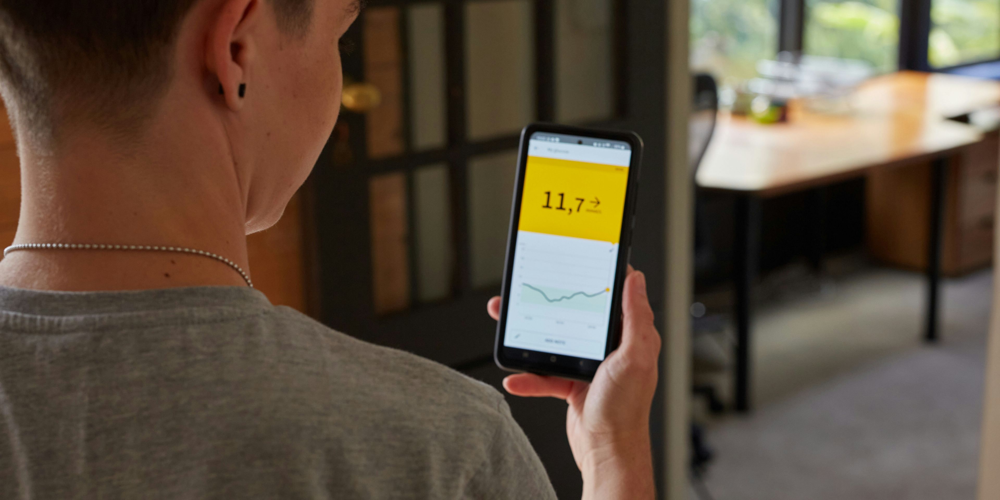 a young person is holding a cell phone in his hand .