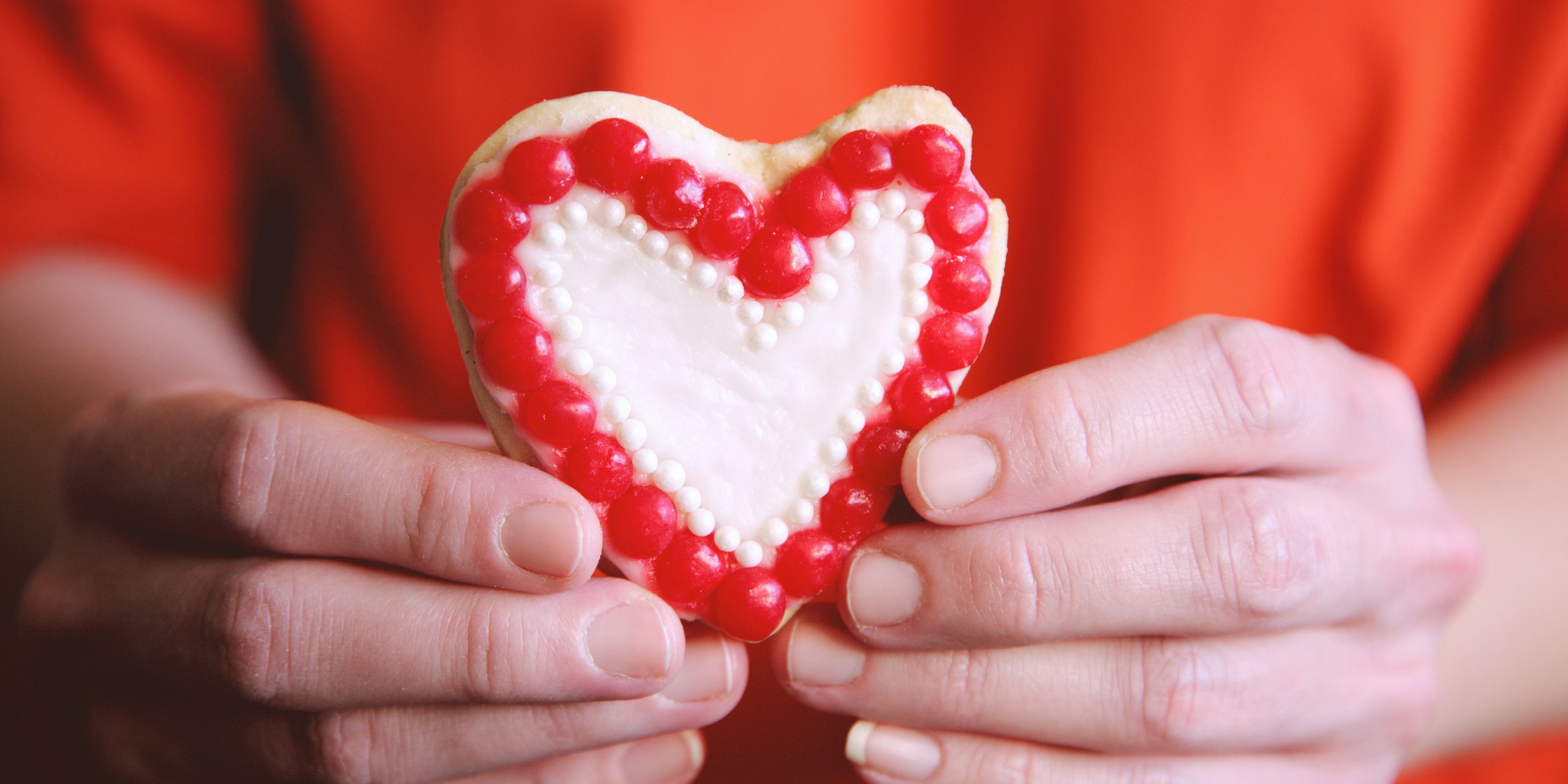 person holding a toy heart symbol