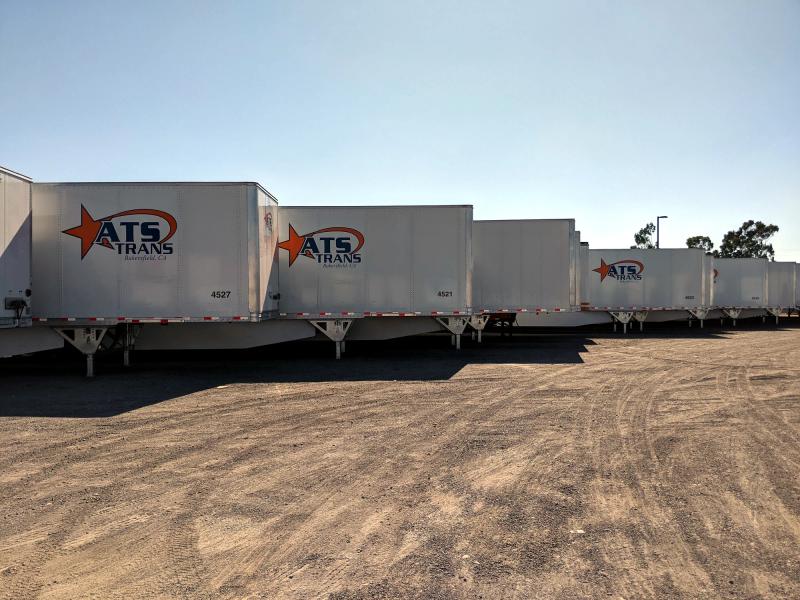Multiple ATS Trans trailers with matching graphics staged in a yard