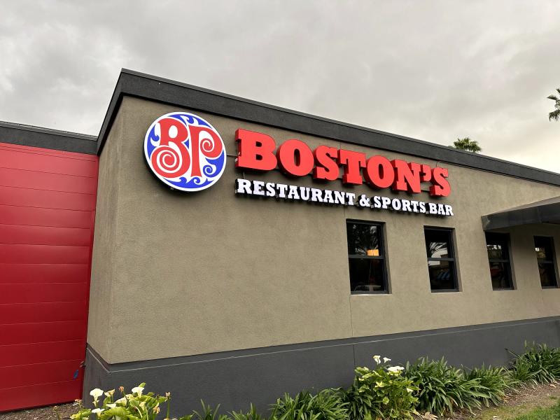 Illuminated channel letters and logo cabinet for Boston's Restaurant & Sports Bar on a corner elevation