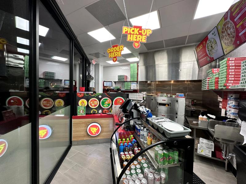 Interior wall and window graphics with menu and order-here wayfinding in a pizza shop