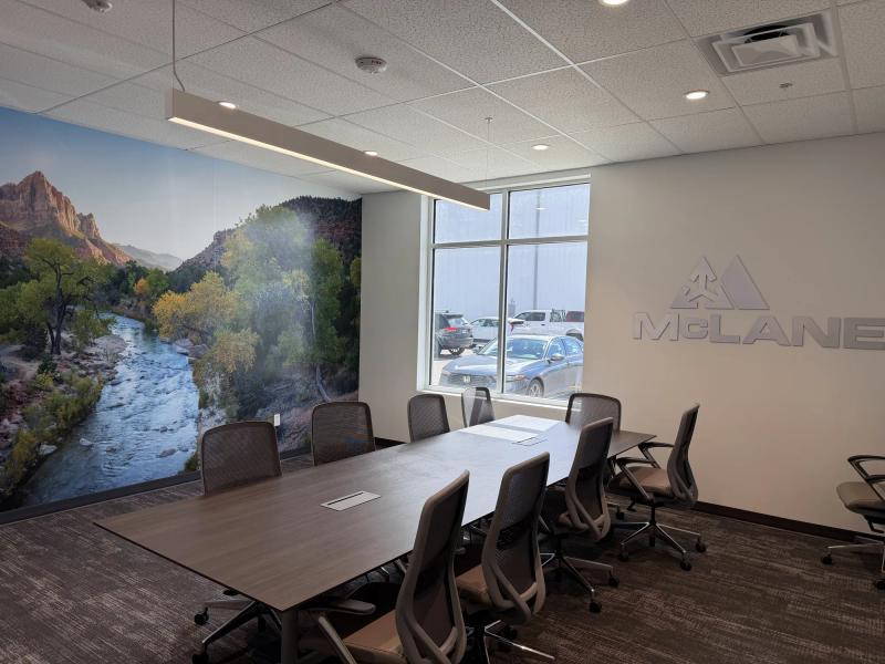 Conference room with a floor-to-ceiling Zion Canyon river mural on one wall and brushed dimensional McLane letters on the adjacent wall