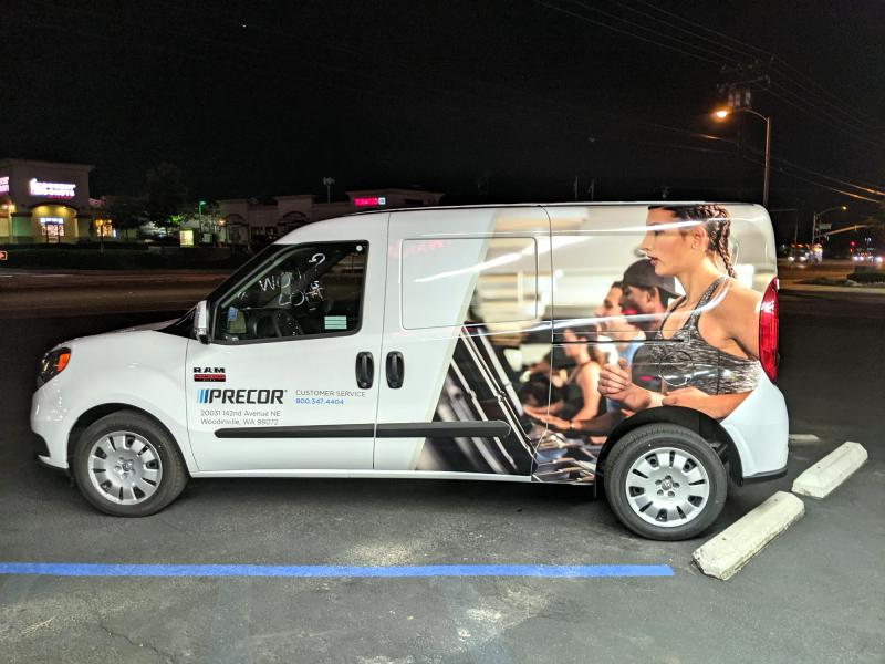 Precor fitness van with partial wrap and lifestyle imagery, photographed at night