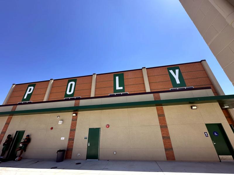 Large individual letters spelling POLY across the top of a school gymnasium