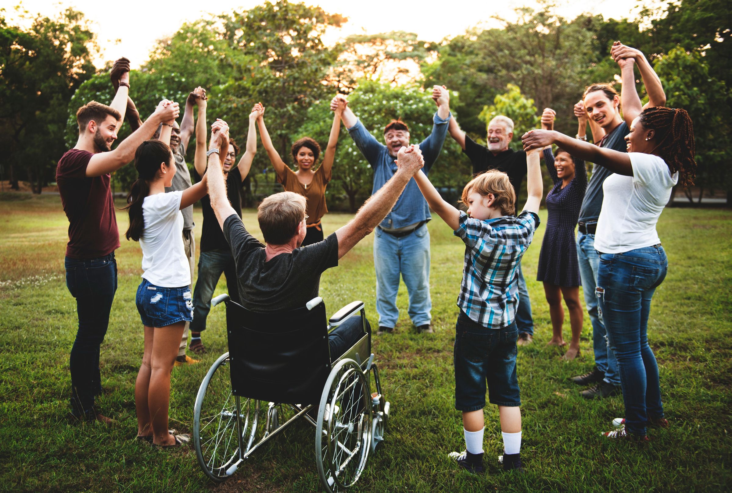 Group of different people all holding hands in a circle celebrating, what do they have in common? They all benefit from the peace of mind that comes from having an estate plan.