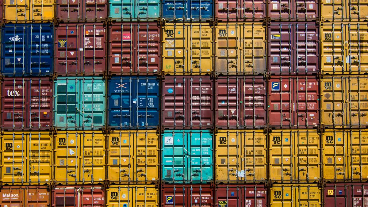 Gestapelte Frachtcontainer im gleichen Raster mit unterschiedlichen Farben als Bild für die Buy-and-Build-Plattform