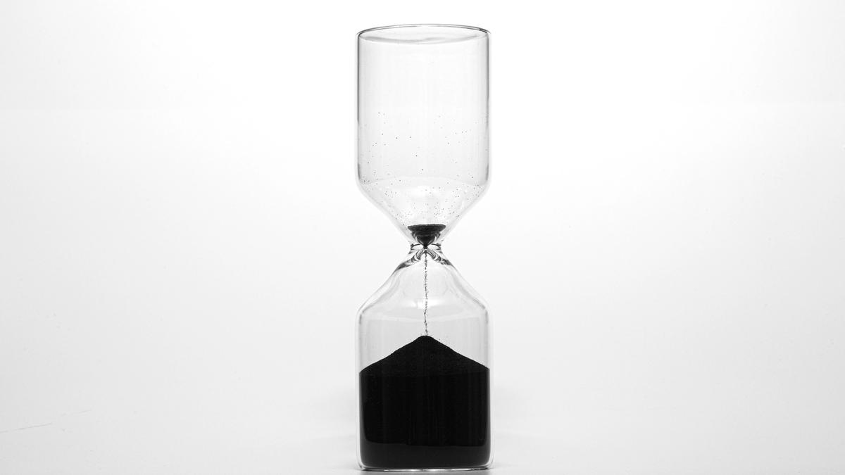 Sanduhr mit schwarzem, fast durchgelaufenem Sand als Sinnbild für Honorarmodelle nach Zeit