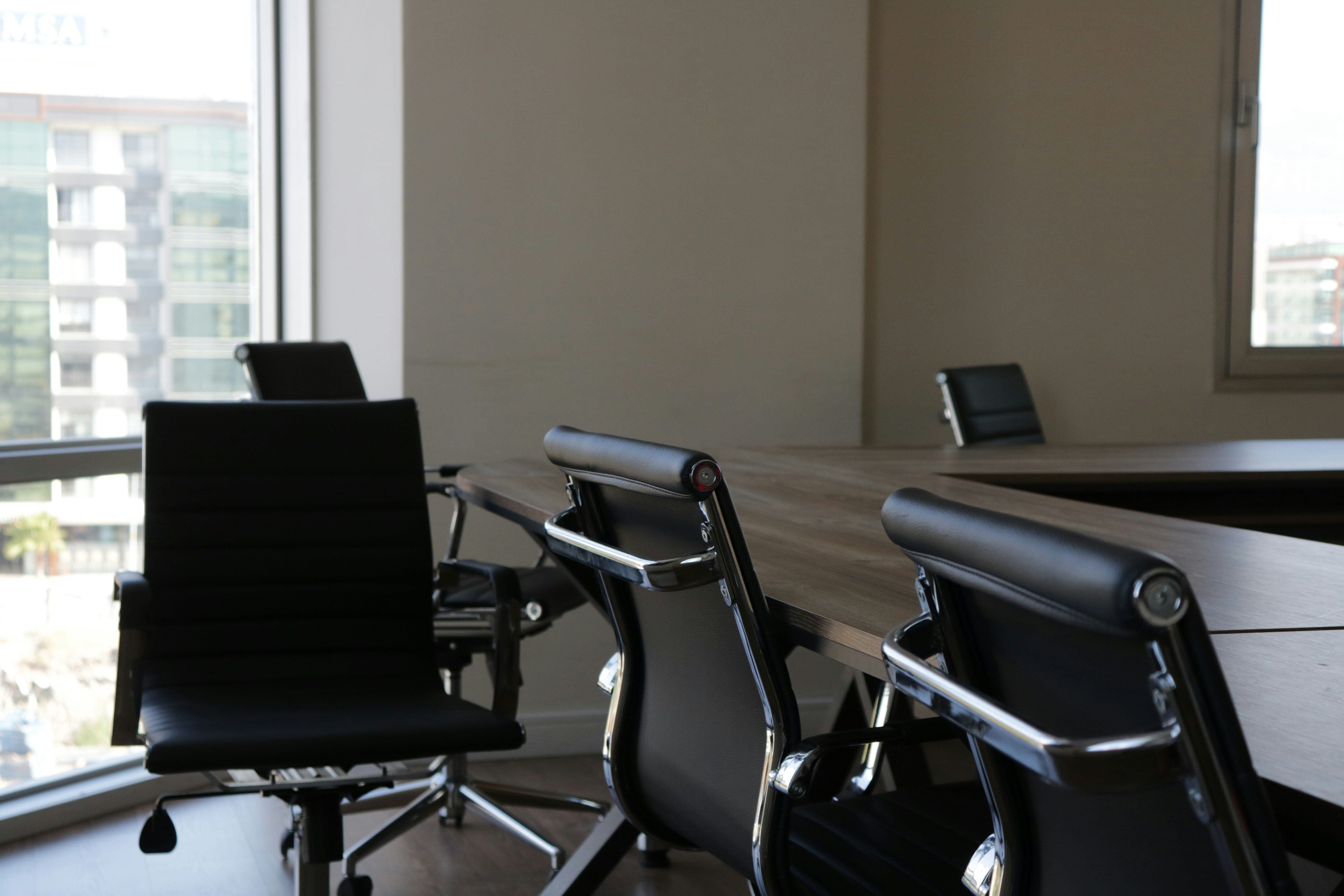 Leere Bürostühle an einem Konferenztisch als Bild dafür, wie SaaS-Preismodelle den Anker am Arbeitsplatz verlieren