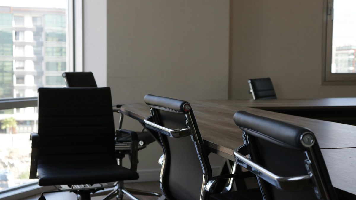 Empty office chairs at a conference table, an image for SaaS pricing models losing their per-seat anchor