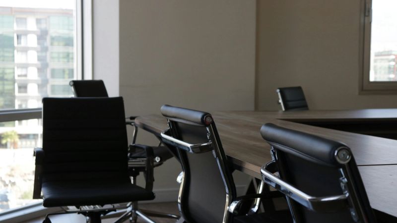 Leere Bürostühle an einem Konferenztisch als Bild dafür, wie SaaS-Preismodelle den Anker am Arbeitsplatz verlieren