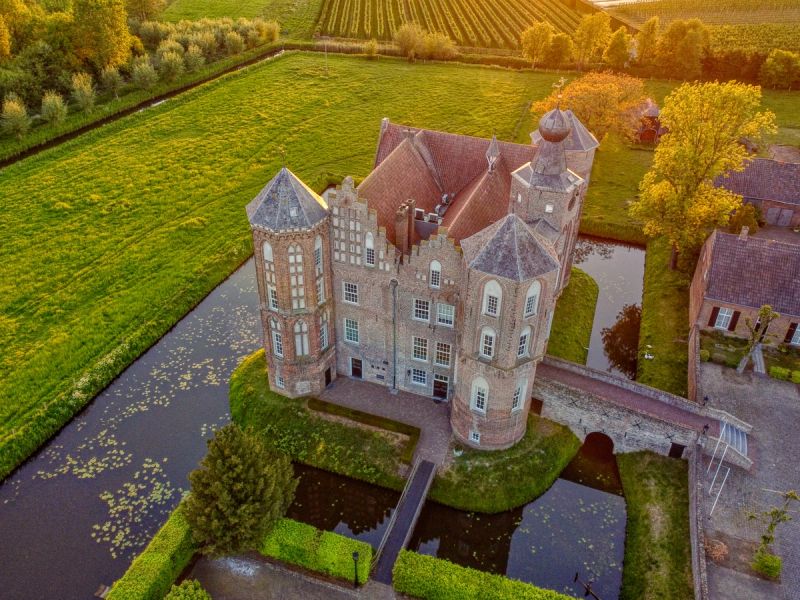 Prachtvolle Wasserburg aus der Luft mit umlaufendem Burggraben und intakten Mauern, Sinnbild für ein verteidigbares B2B-SaaS in der Nische.