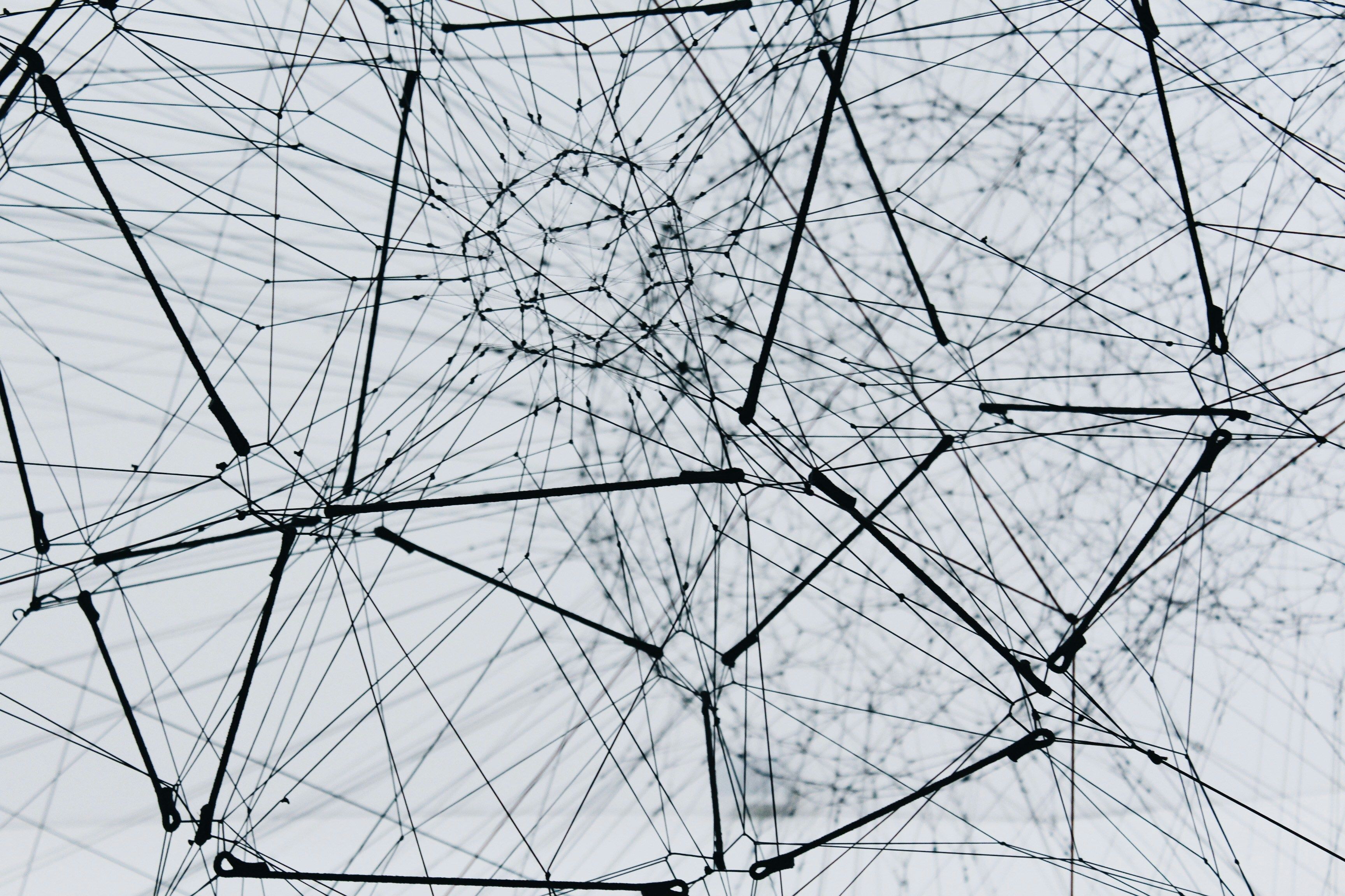 Abstract black-and-white 3D wire network with interconnected nodes, representing knowledge graph architecture and multi-agent systems in AI compliance