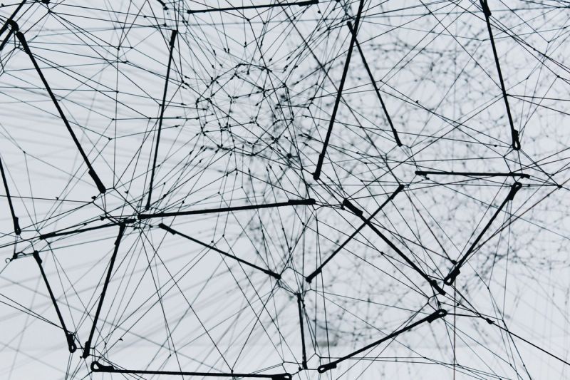 Abstraktes schwarz-weißes 3D-Drahtnetzwerk mit verbundenen Knotenpunkten, Sinnbild für Knowledge-Graph-Architektur und Multi-Agenten-Systeme in der KI-Compliance