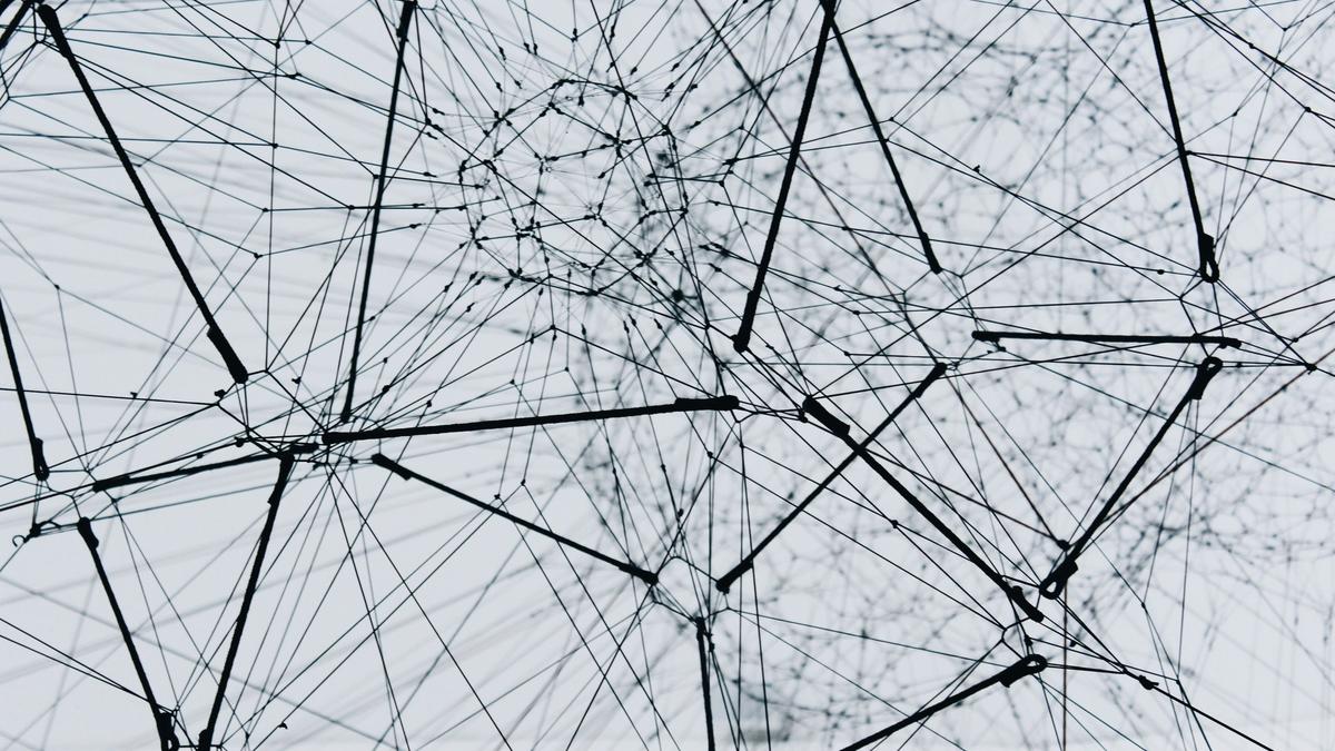 Abstraktes schwarz-weißes 3D-Drahtnetzwerk mit verbundenen Knotenpunkten, Sinnbild für Knowledge-Graph-Architektur und Multi-Agenten-Systeme in der KI-Compliance