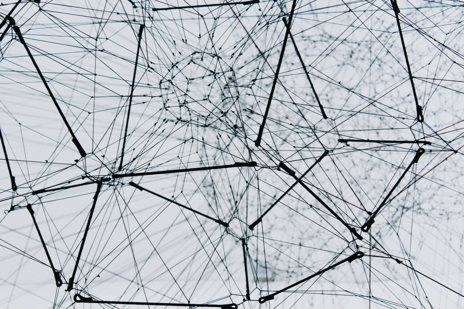 Abstraktes schwarz-weißes 3D-Drahtnetzwerk mit verbundenen Knotenpunkten, Sinnbild für Knowledge-Graph-Architektur und Multi-Agenten-Systeme in der KI-Compliance