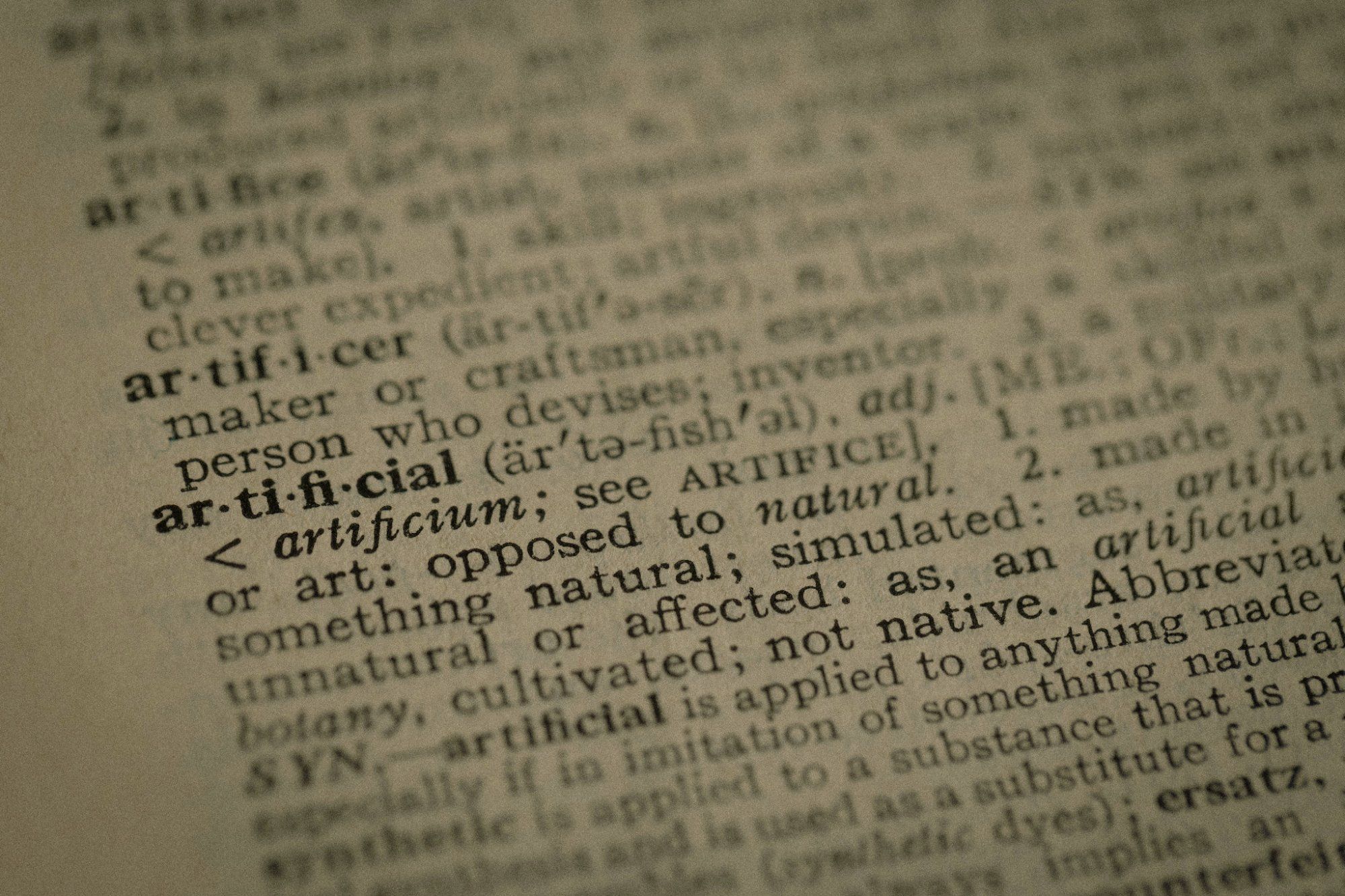 KI-Begriffe für Geschäftsführer, Wörterbucheintrag artificial als Symbol für die Sprache der künstlichen Intelligenz