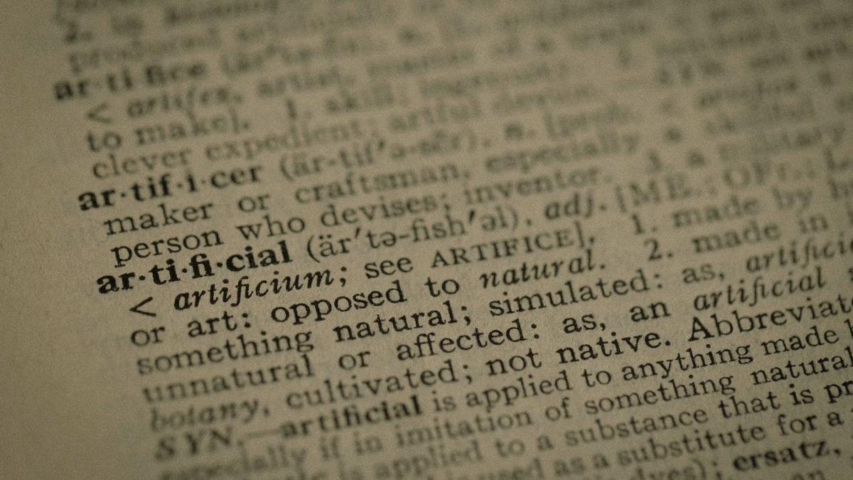 KI-Begriffe für Geschäftsführer, Wörterbucheintrag artificial als Symbol für die Sprache der künstlichen Intelligenz