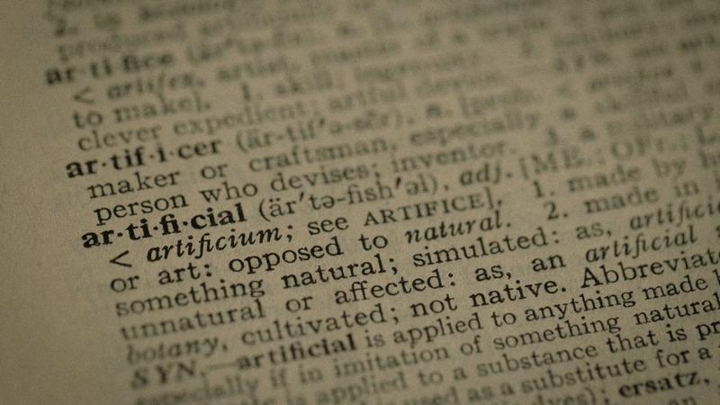 KI-Begriffe für Geschäftsführer, Wörterbucheintrag artificial als Symbol für die Sprache der künstlichen Intelligenz