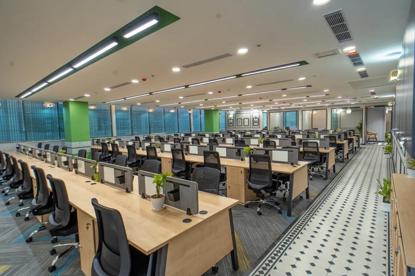 AIHP Atrium open-plan workstation floor with glass cabins and natural light, Sector 32 Gurgaon