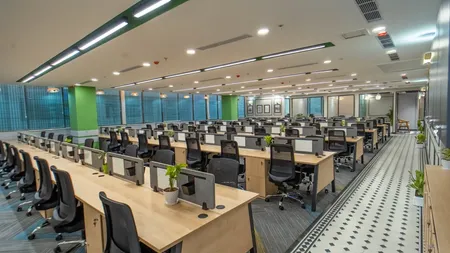 AIHP Atrium open-plan workstation floor with glass cabins and natural light, Sector 32 Gurgaon