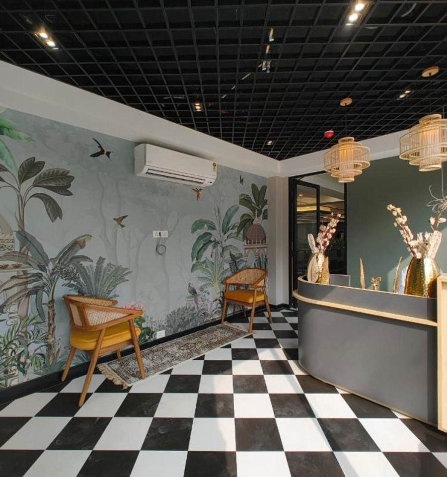 Breakout lounge with accent chairs and a feature mural wall at AIHP Cyber Greens 2
